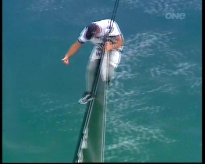 7 - One hand free the other on headboard, gives thumbs up to crew below, probably indicating that the sail is clear to trip. © Event Media